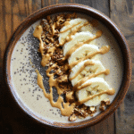Creamy banana peanut butter smoothie bowl with toppings
